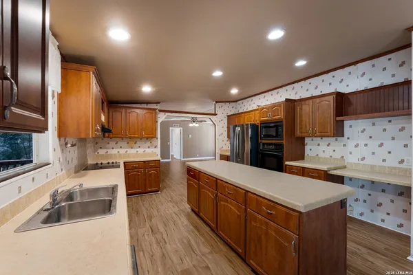 a kitchen with stainless steel appliances kitchen island granite countertop a refrigerator and a stove top oven