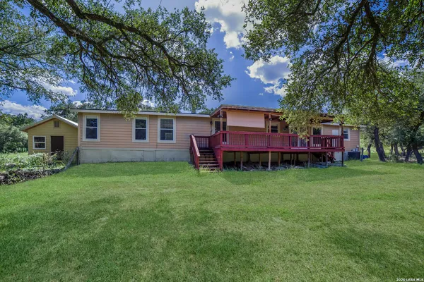 a view of a backyard with wooden fence and a large tree