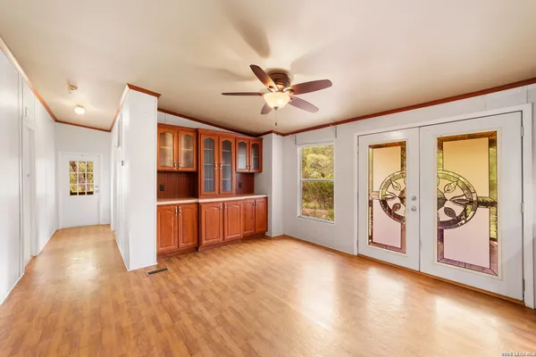 a view of a big room with wooden floor and windows