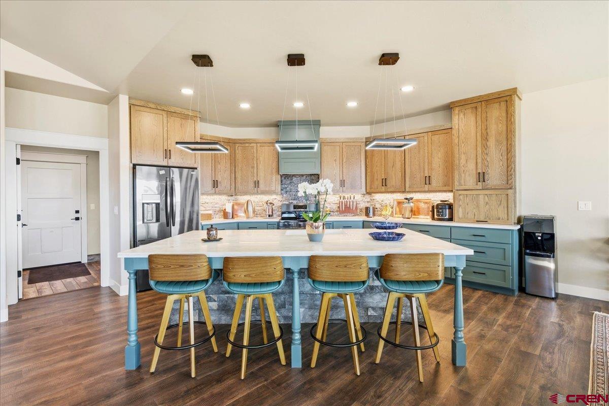 11266 5880 Road Montrose, CO 81403 - Photo 19 of 43 a kitchen with stainless steel appliances kitchen island granite countertop a dining table chairs and a refrigerator