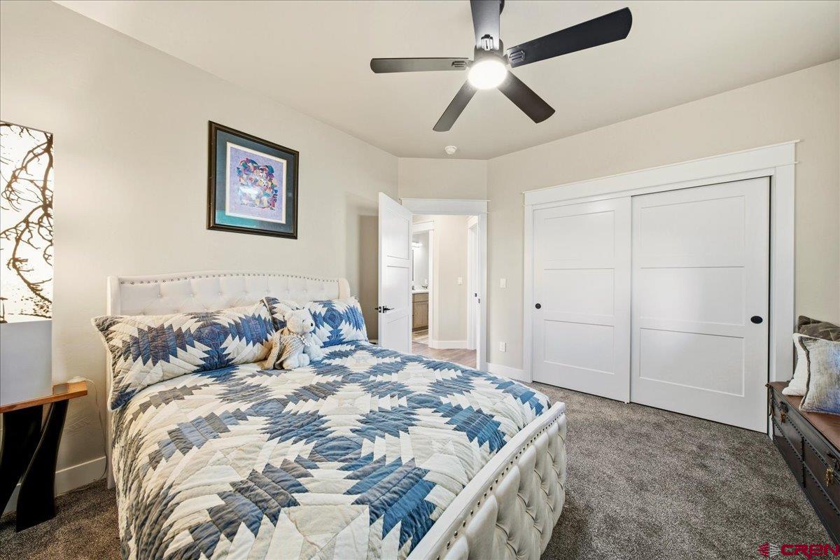 11266 5880 Road Montrose, CO 81403 - Photo 26 of 43 a bedroom with a large bed and a ceiling fan