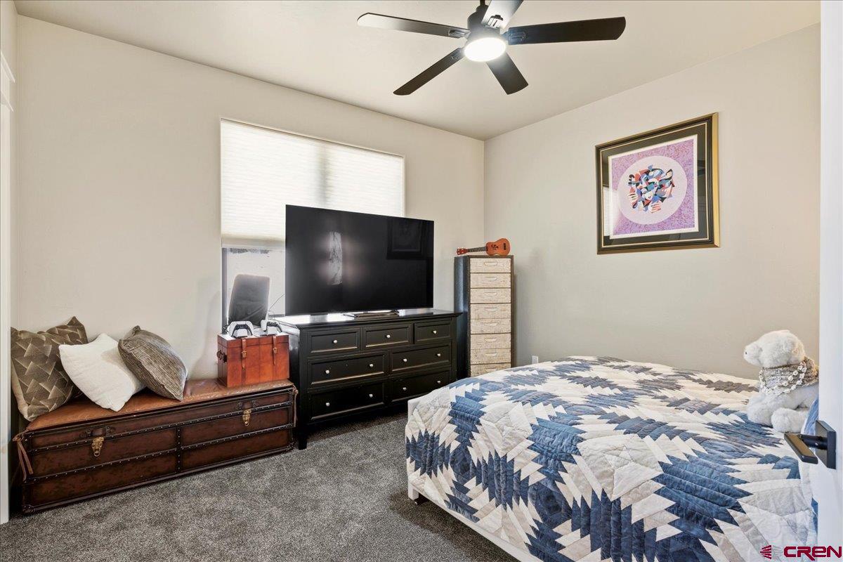 11266 5880 Road Montrose, CO 81403 - Photo 27 of 43 a bedroom with a bed and a flat screen tv