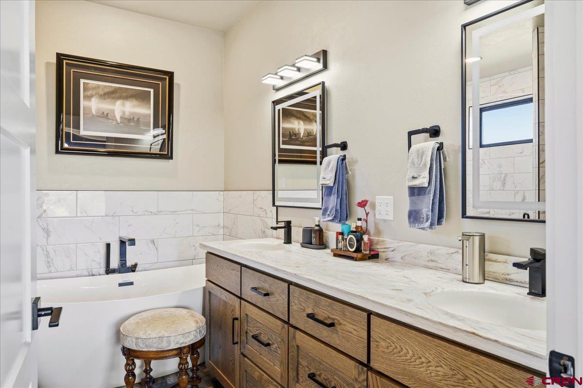 11266 5880 Road Montrose, CO 81403 - Photo 32 of 43 a bathroom with a toilet a sink a mirror and vanity