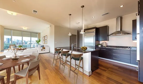 a kitchen with a table chairs stove and wooden floor