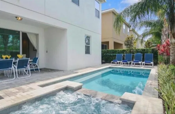 a backyard of a house with table and chairs