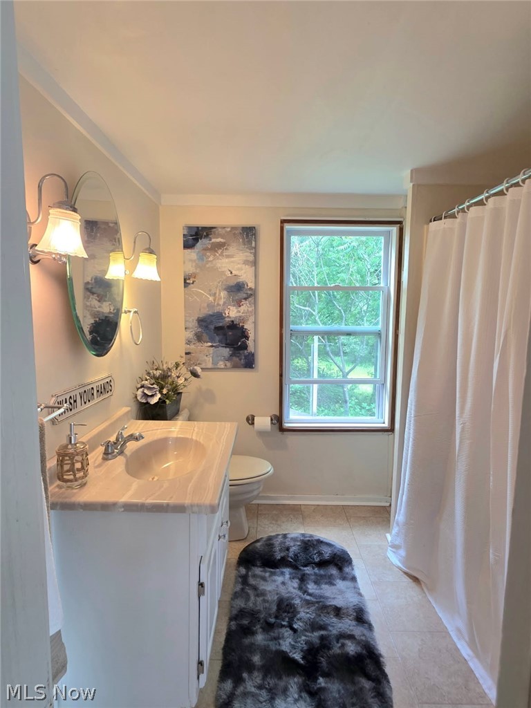398 North Chillicothe Road Aurora, OH 44202 - Photo 18 of 39 Bathroom featuring a white vanity with a light-toned countertop, an oval mirror, and a window with natural light