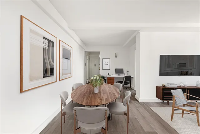a living room with furniture a flat screen tv and kitchen view