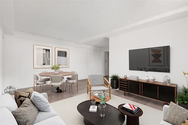 a living room with furniture a flat screen tv and kitchen view