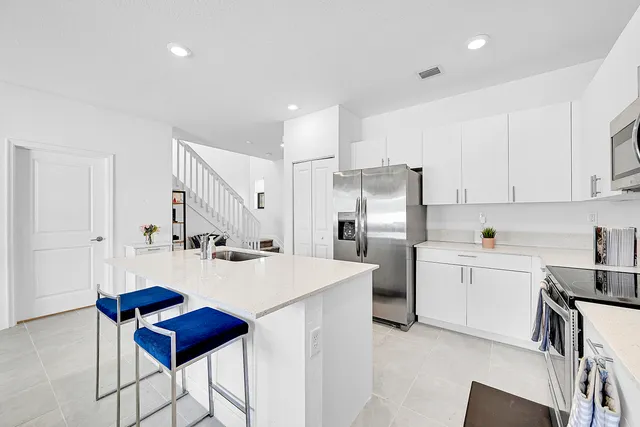 a living room with a sink and a refrigerator