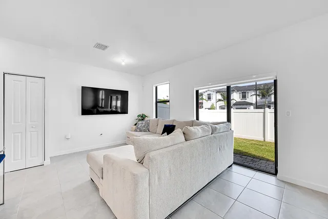 a living room with furniture and kitchen view