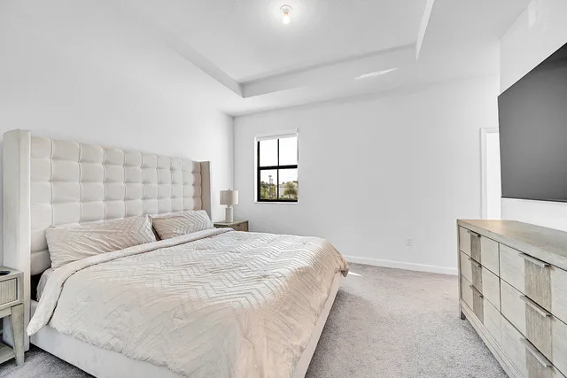 a bedroom with a bed and a flat screen tv in white walls