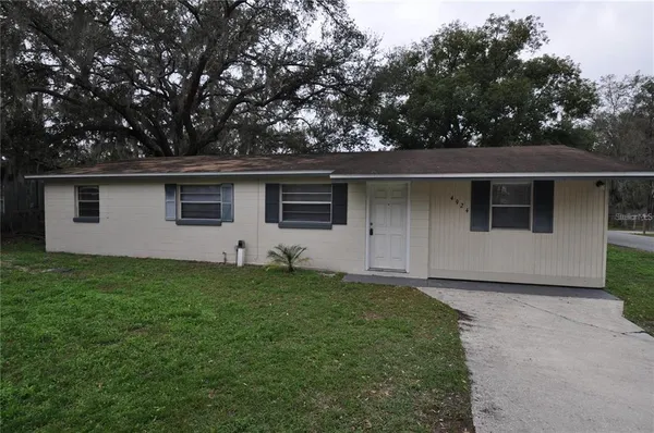 a front view of house with yard and trees