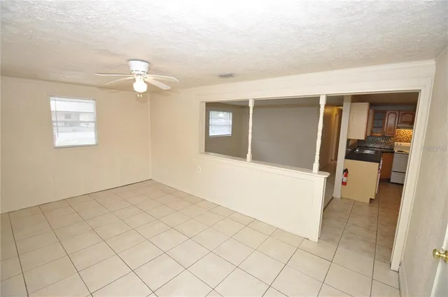 an empty room with chandelier fan