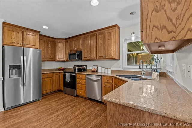 a kitchen with stainless steel appliances granite countertop a refrigerator a stove top oven a sink and dishwasher