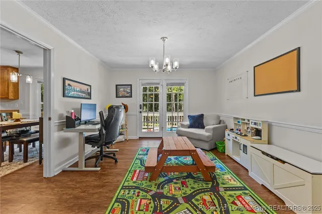 a living room with furniture a large window and a chandelier