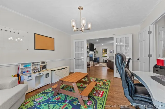 a living room with furniture a rug kitchen view and a chandelier