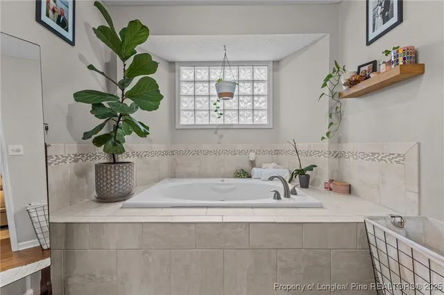 a bathroom with a sink a window and a potted plant