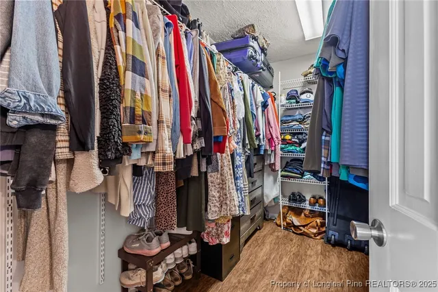 a view of walk in closet with clothes and shoes