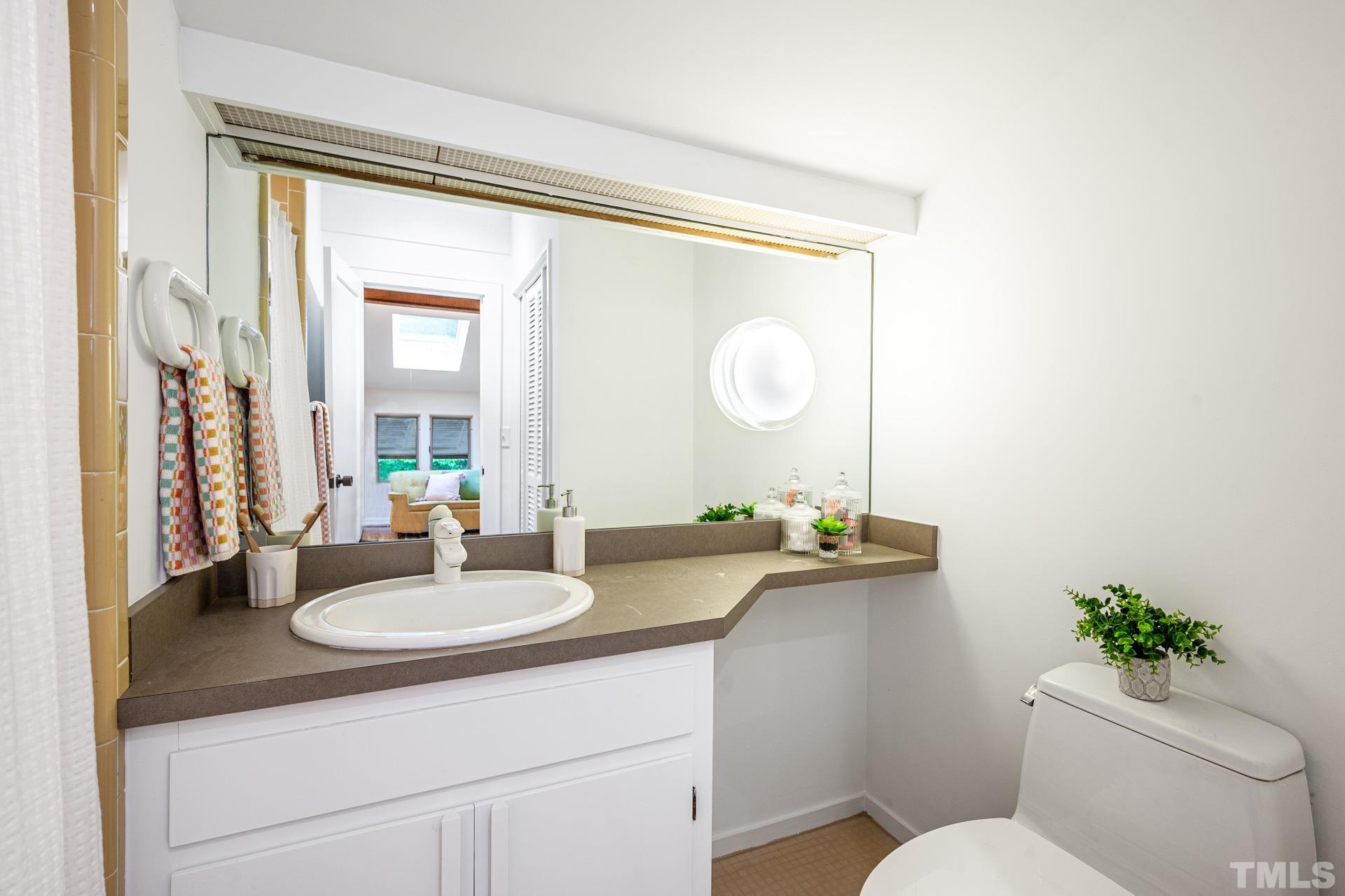 803 Cedar Falls Road Chapel Hill, NC 27514 - Photo 37 of 61 a bathroom with a granite countertop sink toilet and a mirror