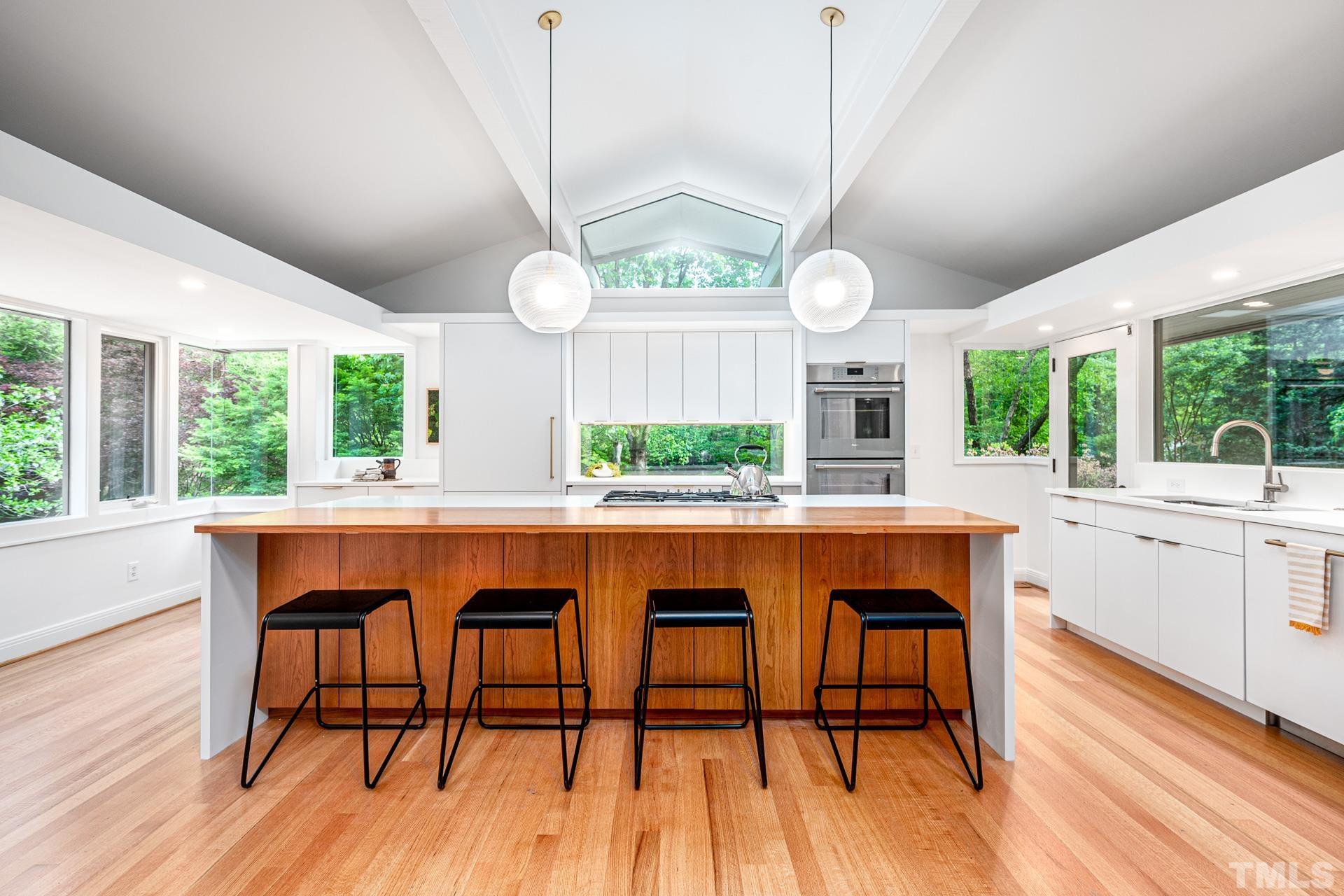 803 Cedar Falls Road Chapel Hill, NC 27514 - Photo 6 of 61 a dining room with wooden floor a chandelier a wooden table and chairs
