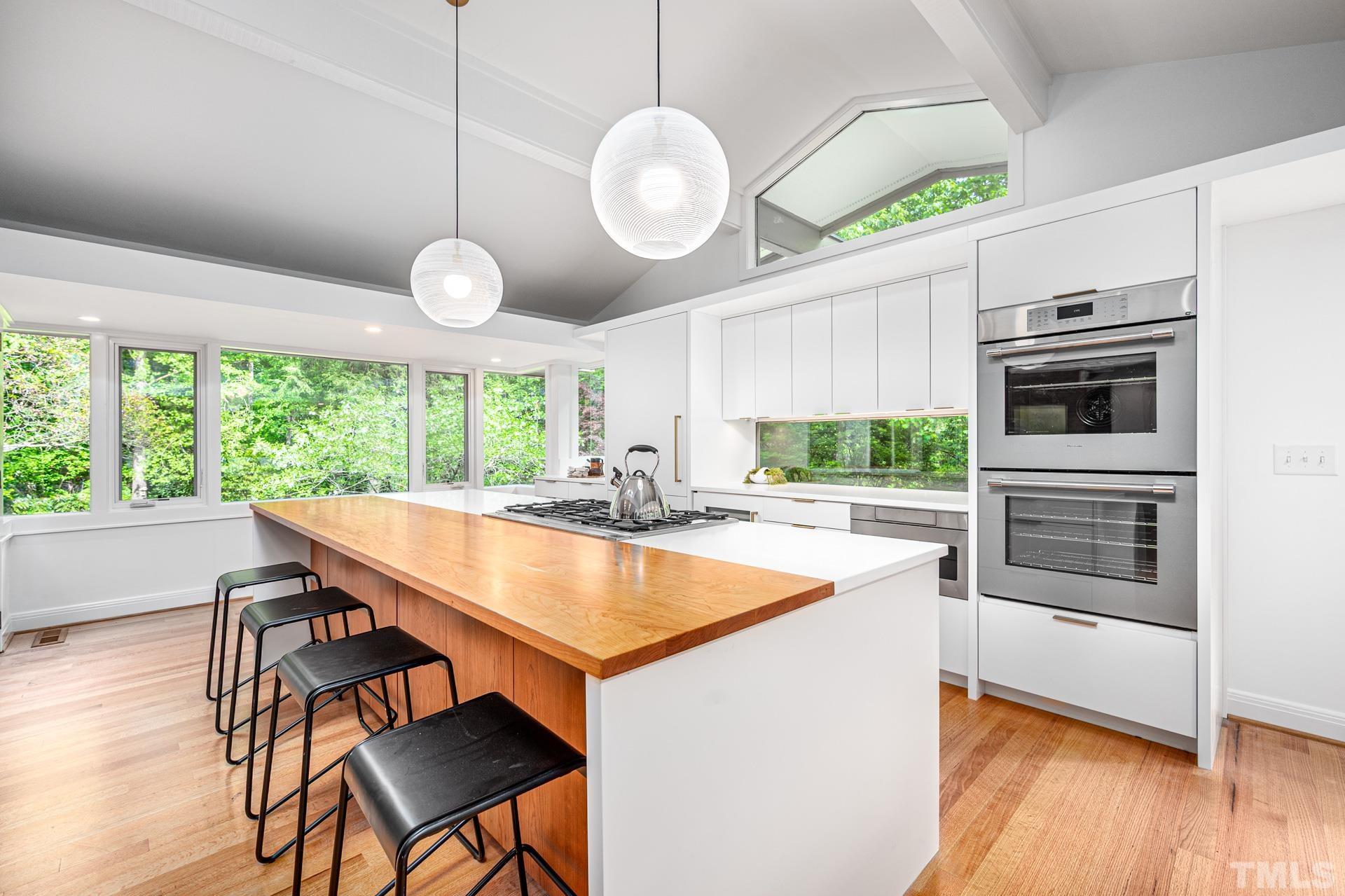 803 Cedar Falls Road Chapel Hill, NC 27514 - Photo 7 of 61 a kitchen with stainless steel appliances granite countertop a stove a kitchen island a table and chairs in it