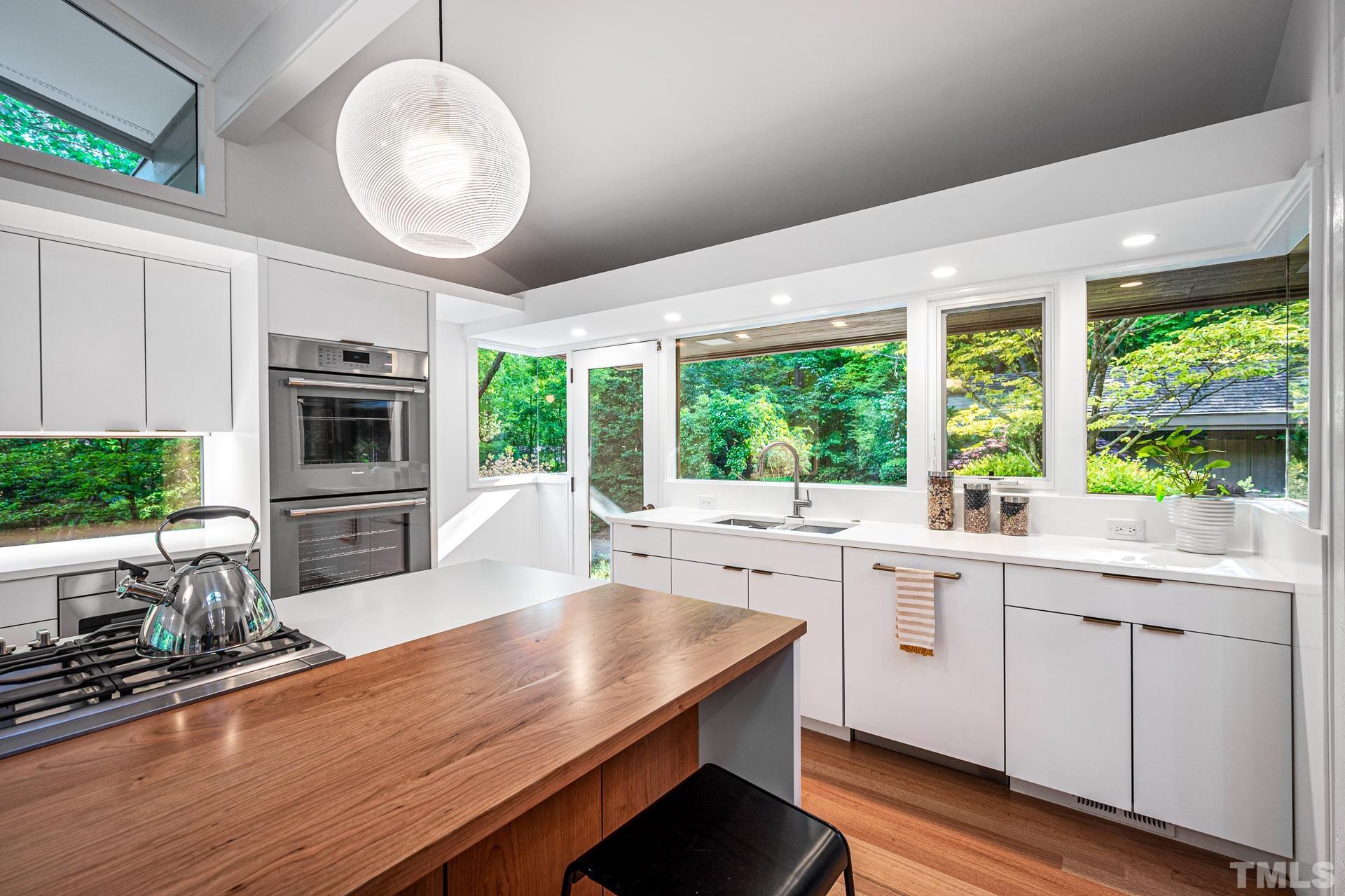 803 Cedar Falls Road Chapel Hill, NC 27514 - Photo 9 of 61 a kitchen with a stove a sink a microwave cabinets and wooden floor
