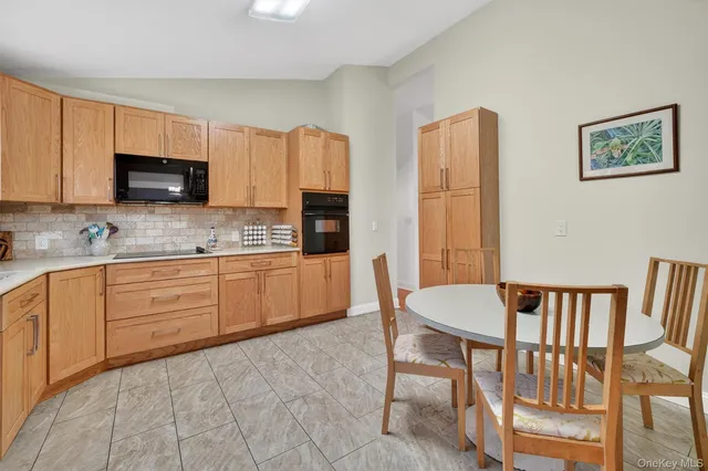 a kitchen with stainless steel appliances granite countertop a stove a sink dishwasher a refrigerator with a dining table and chairs