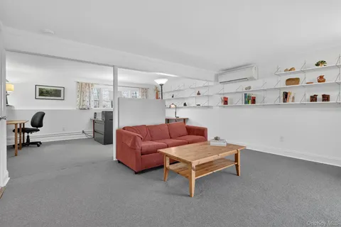 a view of a workspace with furniture and a window