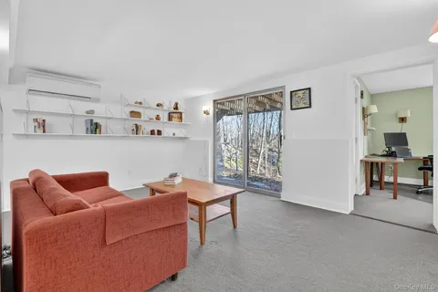 a view of a workspace with furniture and a window