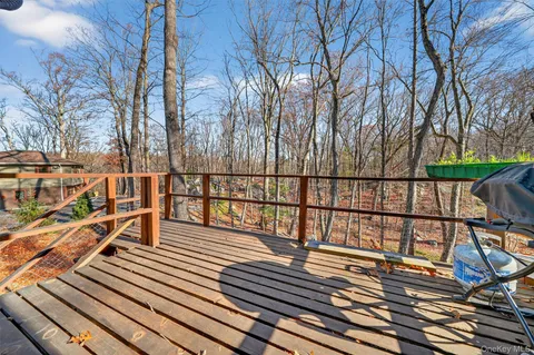 a backyard of a house with large trees and wooden fence