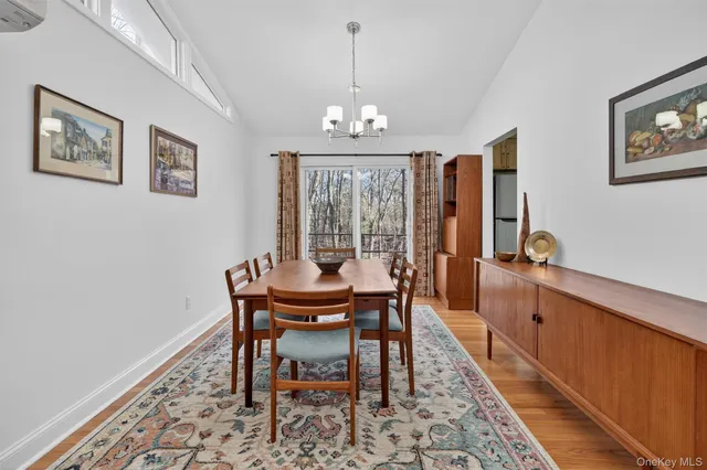 a dining room with wooden floor and a chandelier