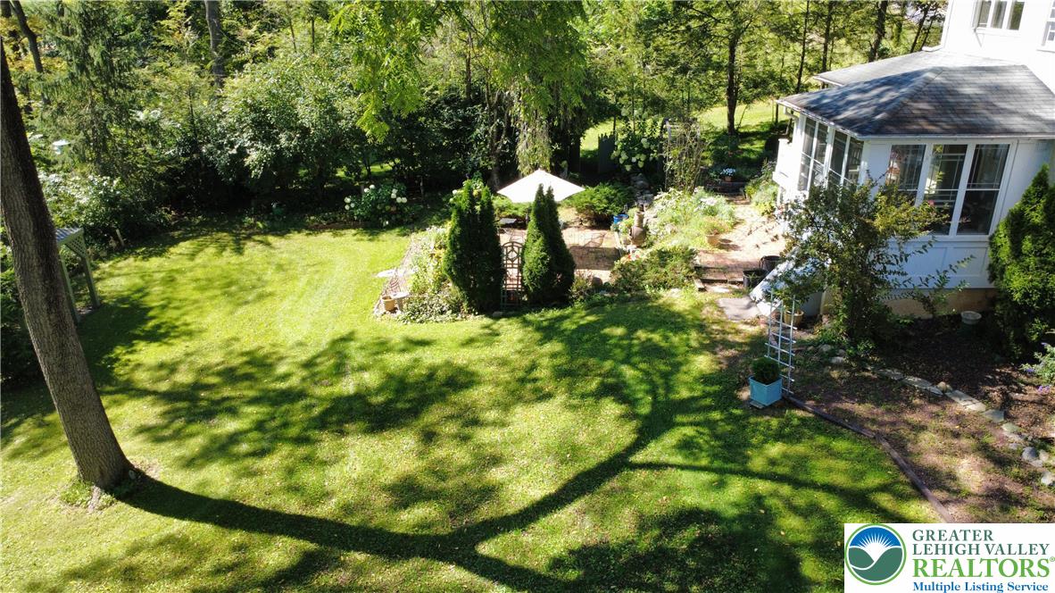1731 Howell Road Easton, PA 18040 - Photo 55 of 60 Mature trees frame a verdant lawn bordering the home's sunroom and garden patio area.