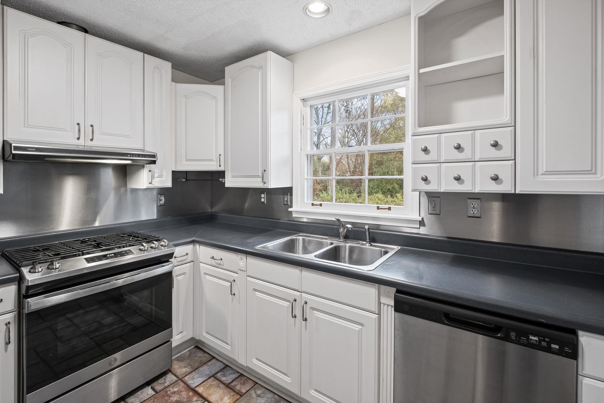2432 Hawkhurst Street Memphis, TN 38119 - Photo 10 of 31 a kitchen with granite countertop a sink a stove and cabinets