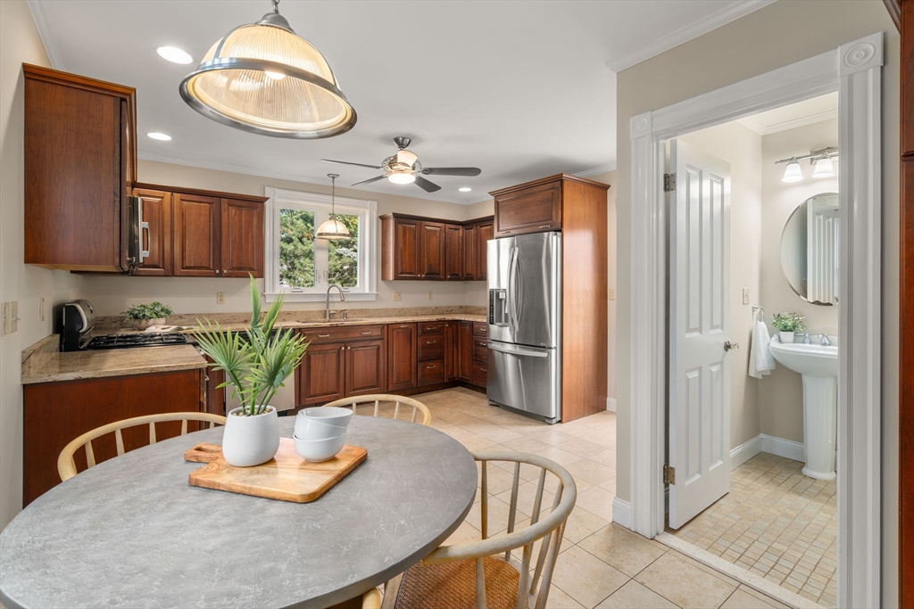 110 Mt Vernon Street Dedham, MA 02026 - Photo 15 of 35 a kitchen with stainless steel appliances granite countertop a refrigerator a stove a sink and a dining table with wooden cabinet