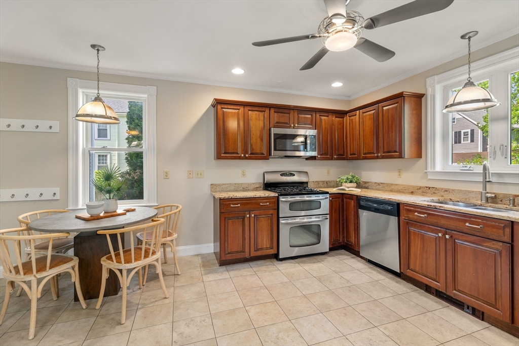 110 Mt Vernon Street Dedham, MA 02026 - Photo 16 of 35 a kitchen with stainless steel appliances granite countertop a stove top oven a sink a stove a dining table and chairs