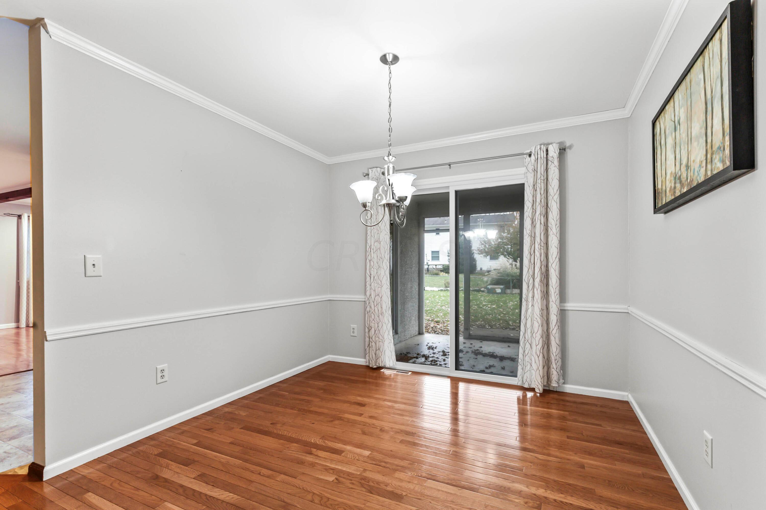 7020 Rieber Street Columbus, OH 43085 - Photo 8 of 40 • New hardwood flooring ~ 2012 • Grey painted walls • Crown molding • New chandelier ~ 2012 • Sliding doors to screened porch • Drapes are negotiable