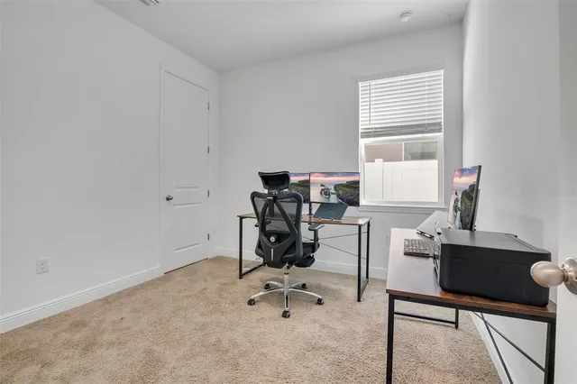 a view of a workspace with furniture and a window