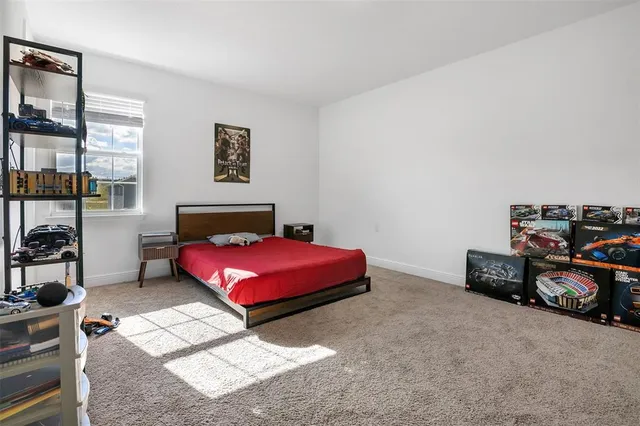 a bedroom with a bed and a painting on the wall