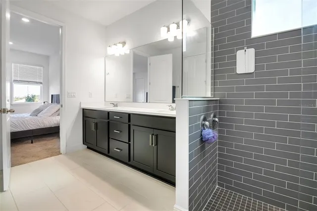 a spacious bathroom with a double vanity sink a mirror and a shower