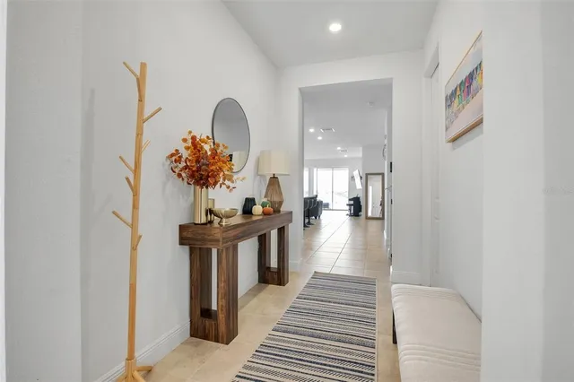 a view of a hallway with a couch and chandelier