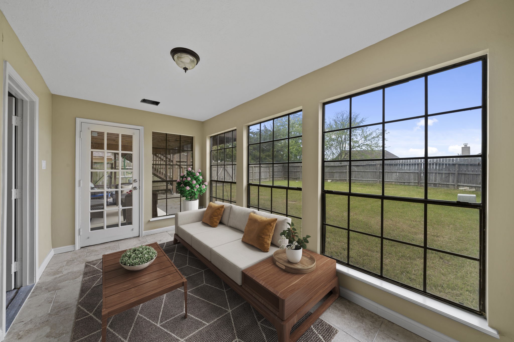 169 April Cove Montgomery, TX 77356 - Photo 9 of 39 Virtually Staged: Bright and inviting sunroom filled with natural light, featuring expansive windows that create a seamless connection to the outdoors. This versatile space is perfect for relaxing, enjoying morning coffee, or creating a cozy sitting area with year-round views.