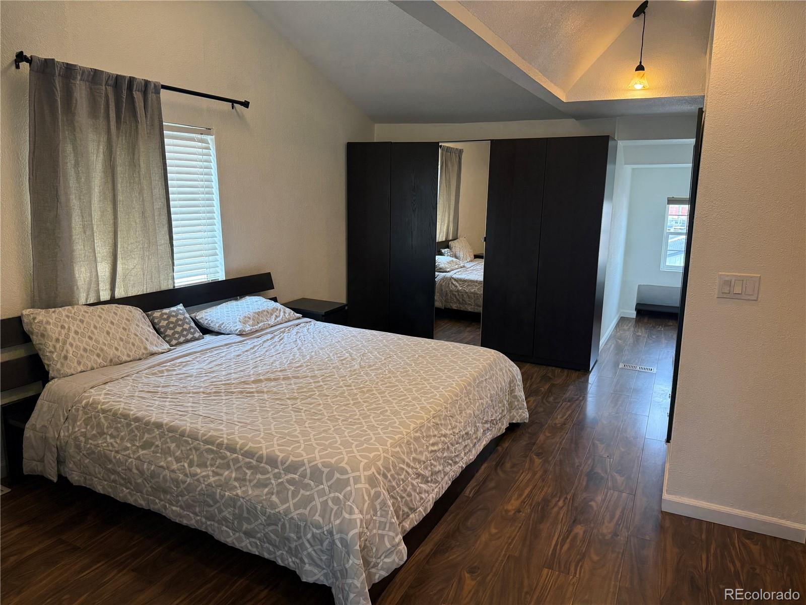 4353 Kalamath Street Denver, CO 80211 - Photo 22 of 28 a bedroom with a bed and wooden floor