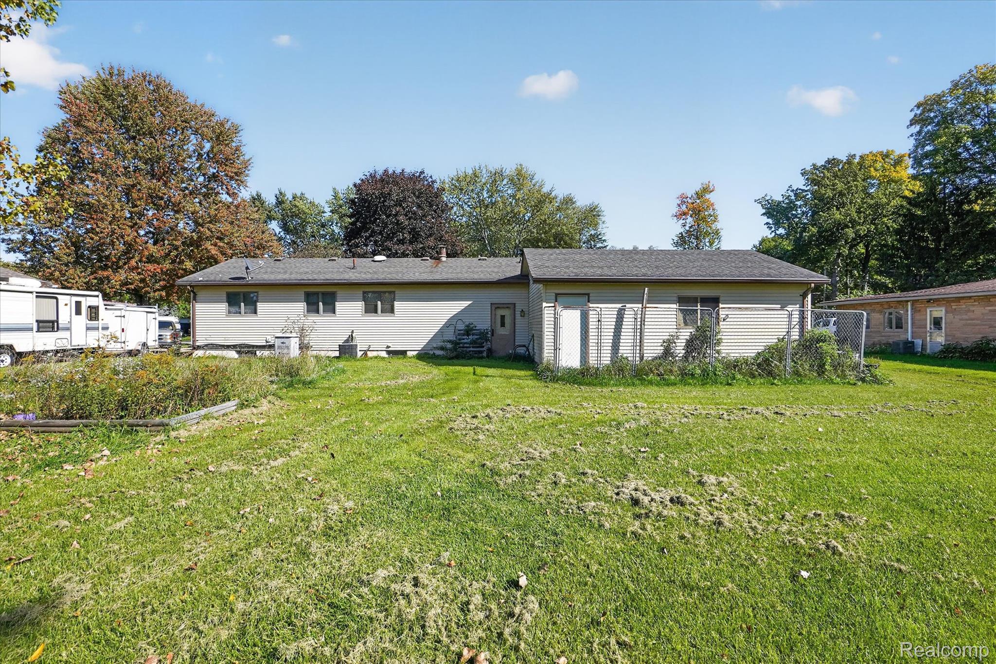 7178 Riegler Street Grand Blanc, MI 48439 - Photo 27 of 31 Expansive green space with mature trees and a detached structure