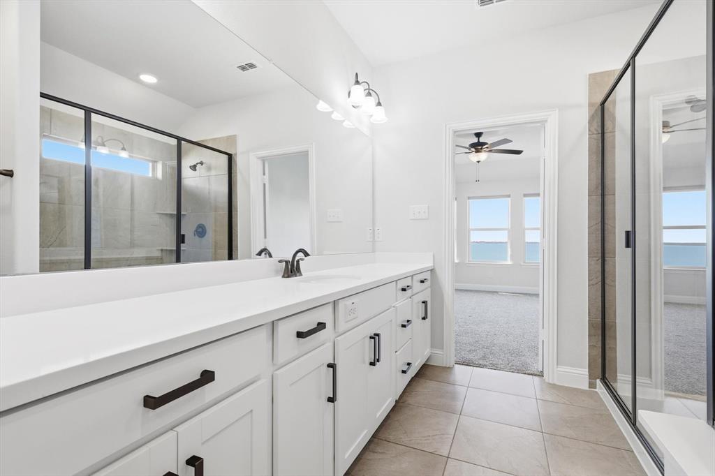 18140 Lakefront Court Forney, TX 75126 - Photo 27 of 37 Bathroom with vanity, a stall shower, light tile patterned flooring, and light carpet