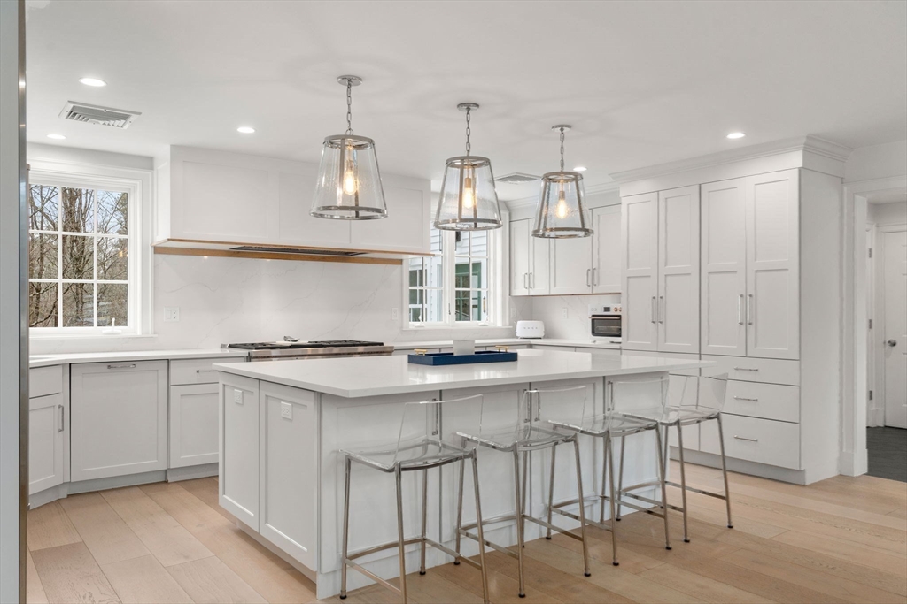 389 Grove Street Needham, MA 02492 - Photo 11 of 40 a kitchen with stainless steel appliances granite countertop a stove and white cabinets