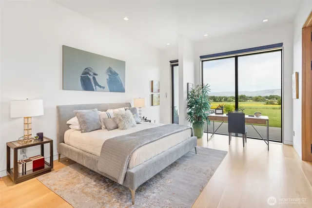 a bedroom with a bed and a large window