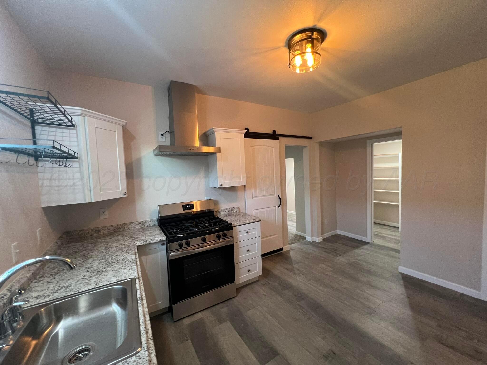 817 South 6th Street Memphis, TX 79245 - Photo 13 of 43 a kitchen with granite countertop a stove and a sink