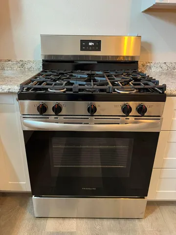 a stove top oven sitting inside of a kitchen