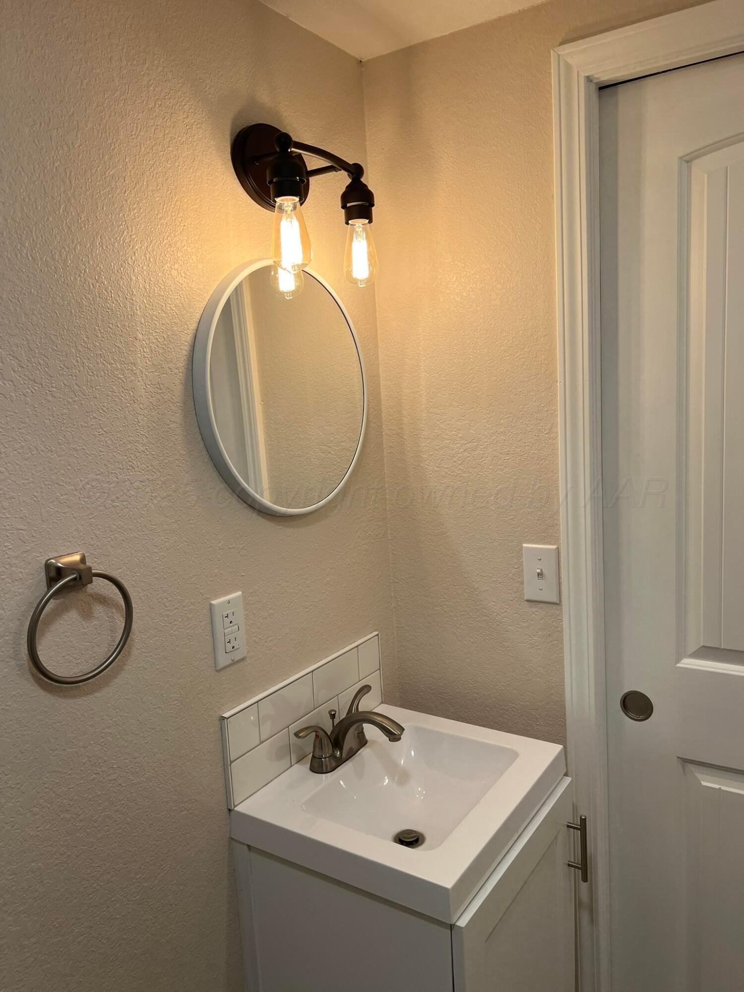817 South 6th Street Memphis, TX 79245 - Photo 31 of 43 a bathroom with a sink and a mirror