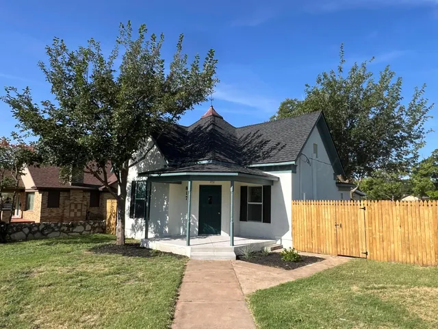 a front view of a house with a yard and potted plants
